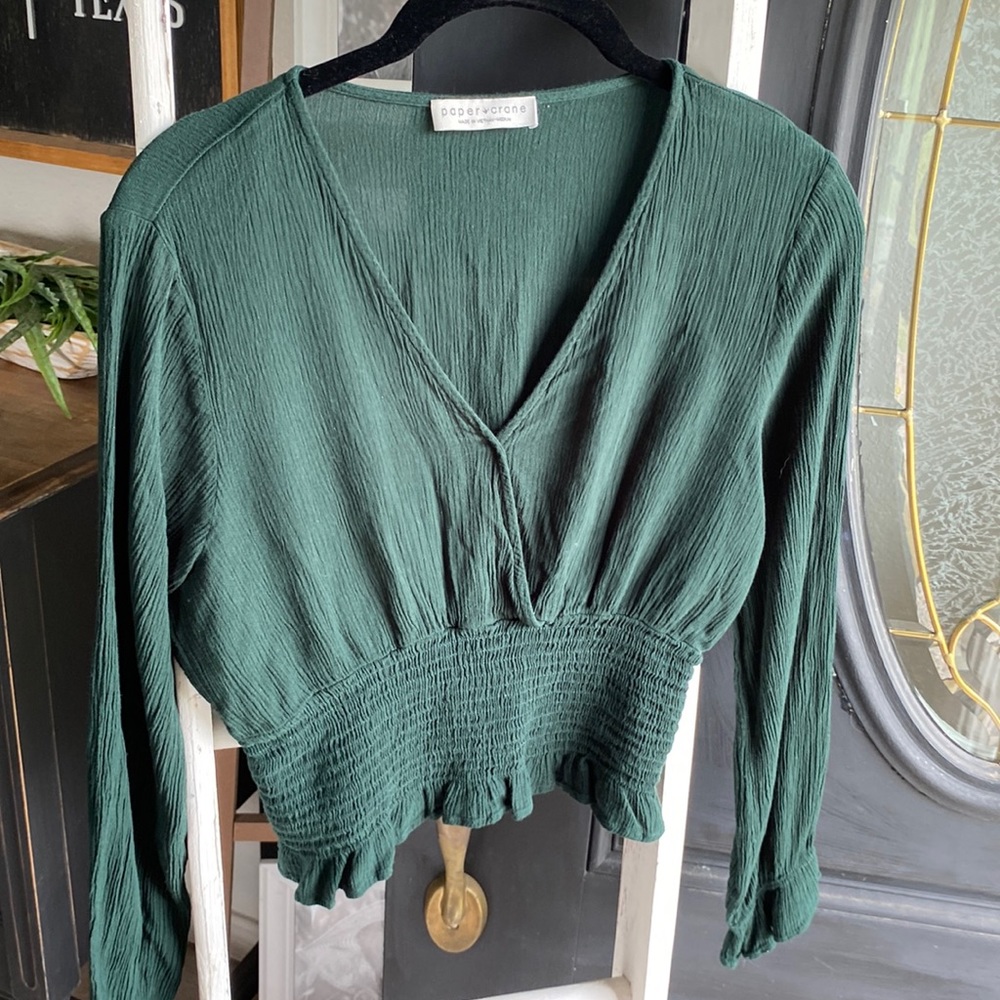 dark green top with ruffled sleeves around wrist